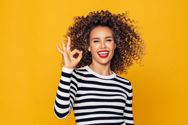 Smiling woman doing OK sign with her hands